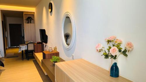 a living room with a vase of flowers on the wall at SS Staycation @Roxy Sematan Beach Apt in Sematan