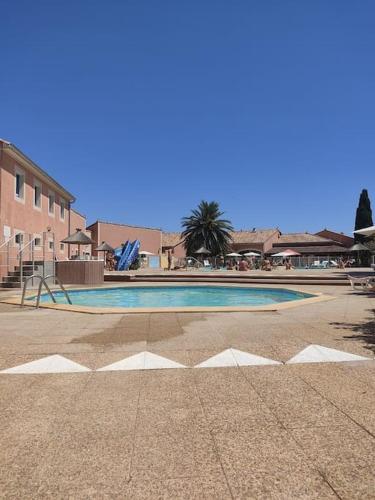 une piscine au milieu d'une cour dans l'établissement Maisonnette de vacances, au Barcarès