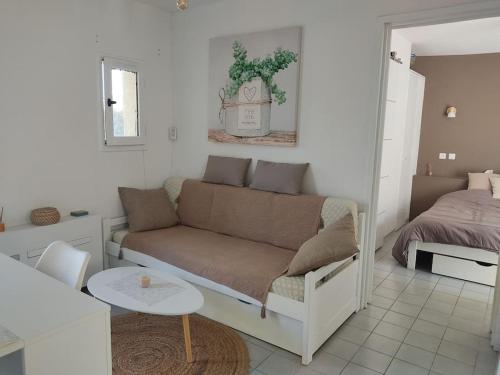 un salon avec un canapé et un lit dans l'établissement Maisonnette de vacances, au Barcarès