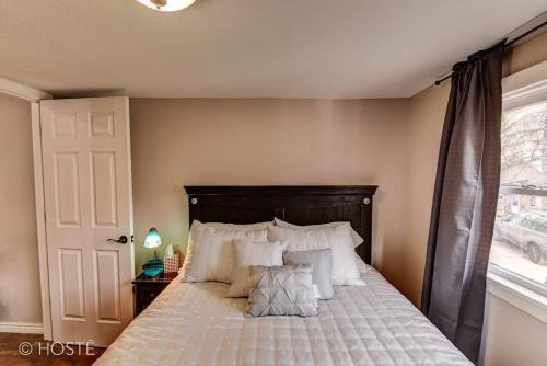 a bedroom with a bed with white pillows and a window at 3BR Manitou Springs 2min to Restaurants Hot Tub in Manitou Springs