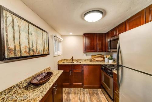 a kitchen with wooden cabinets and a refrigerator at 3BR Manitou Springs 2min to Restaurants Hot Tub in Manitou Springs