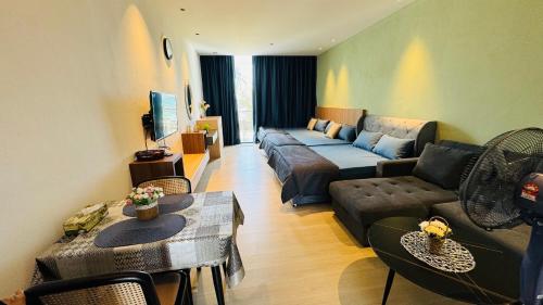 a living room with a couch and a table and chairs at SS Staycation @Roxy Sematan Beach Apt in Sematan