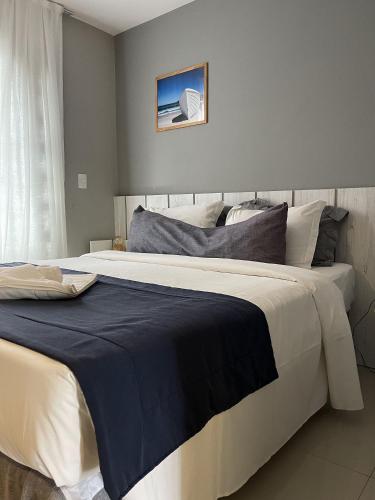 a bedroom with a large bed with a blue blanket at hihome - Royale in Cabo Frio