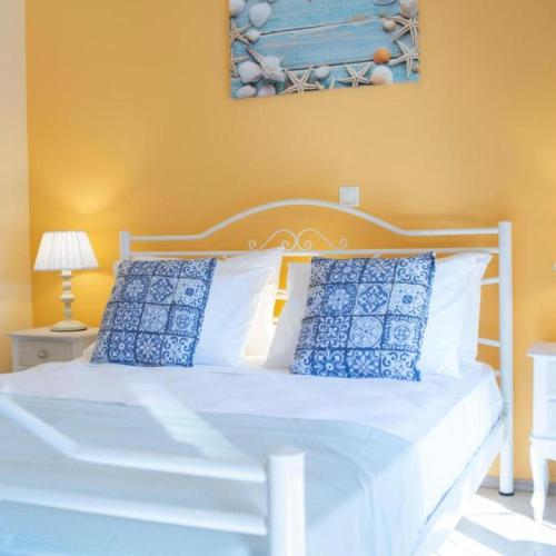 1 dormitorio con cama blanca y almohadas azules en Polyxenis Cozy Maisonette - Lefkada BnB, en Lefkada