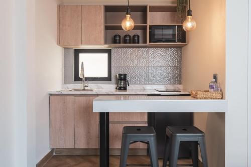a kitchen with a white counter and two stools at Second Home Tamesis in Mexico City