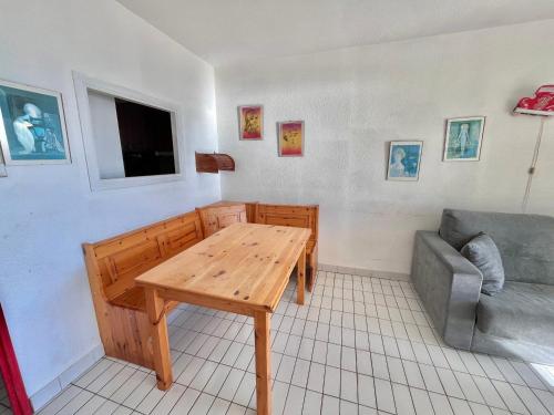 un salon avec une table en bois et un canapé dans l'établissement Appartement en bord de plage avec garage - FR-1-716-39, à La Grande Motte