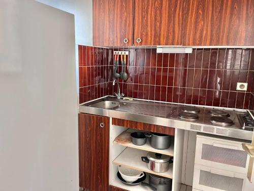 une petite cuisine avec un évier et une cuisinière dans l'établissement Appartement en bord de plage avec garage - FR-1-716-39, à La Grande Motte