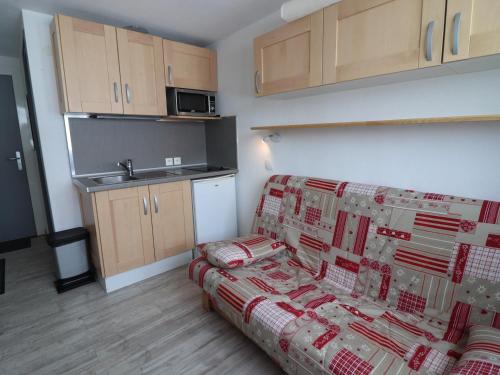 un salon avec un canapé et une cuisine dans l'établissement Studio lumineux au pied des pistes, proche commerces et ESF - FR-1-502-561, à Tignes