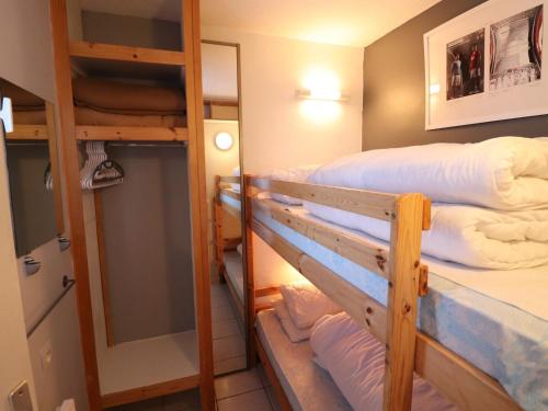une chambre avec deux lits superposés et un miroir dans l'établissement Appartement cosy 2P cabine, skis aux pieds à Tignes, balcon, parking, animaux acceptés, WiFi - FR-1-502-562, à Tignes