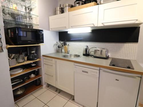 une petite cuisine avec un évier et un micro-ondes dans l'établissement Appartement cosy 2P cabine, skis aux pieds à Tignes, balcon, parking, animaux acceptés, WiFi - FR-1-502-562, à Tignes
