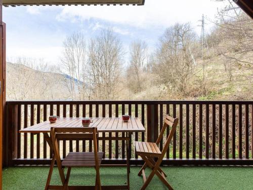 une table et deux chaises assises sur une terrasse couverte dans l'établissement Appartement Confort 6 Personnes à Loudenvielle, Proche Skyvall, Balnéa et Lac - FR-1-695-54, à Loudenvielle
