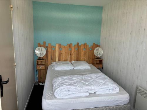 une chambre avec un lit avec une tête de lit en bois dans l'établissement Duplex à 300m de la plage, parking privatif, animaux admis - FR-1-465-116, à Merville-Franceville-Plage