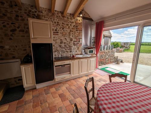 une cuisine avec une table, une table et une table dans l'établissement Chaleureux Gîte avec Terrasse à Proximité de la Loire et des Sites Touristiques - FR-1-590-433, à Bonnée