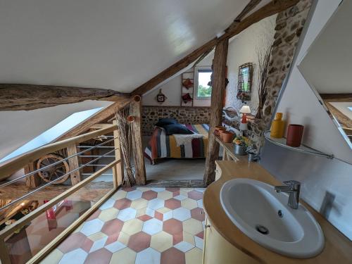 a bathroom with a sink and a bed in a room at Chaleureux Gîte avec Terrasse à Proximité de la Loire et des Sites Touristiques - FR-1-590-433 in Bonnée