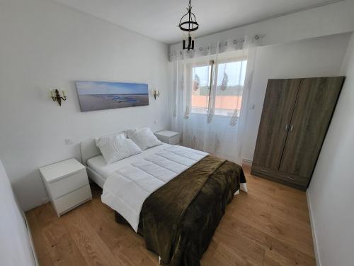 - une chambre blanche avec un lit et un canapé dans l'établissement Appartement 2 chambres avec terrasse et garage privatif proche plage - FR-1-92-940, à Les Sables-dʼOlonne