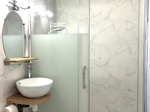 une salle de bain avec une douche avec un lavabo et un miroir dans l'établissement Appartement en Front de Mer avec Parking Privatif à St Jean de Monts - Accès Direct Plage & Pistes Cyclables - FR-1-652-42, à Saint-Jean-de-Monts