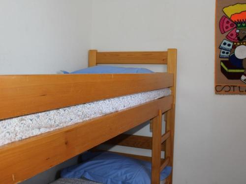 - un lit superposé avec des oreillers bleus au-dessus dans l'établissement Appartement 6 couchages avec piscine à Gruissan - FR-1-229-888, à Gruissan