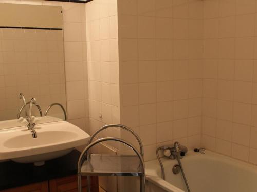 La salle de bains est pourvue d'un lavabo et d'une baignoire à côté d'un miroir. dans l'établissement Appartement 6 couchages avec piscine à Gruissan - FR-1-229-888, à Gruissan