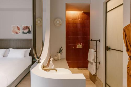 a bathroom with a bed and a sink and a shower at Basq House in Byron Bay