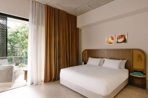 a bedroom with a white bed and a large window at Basq House in Byron Bay