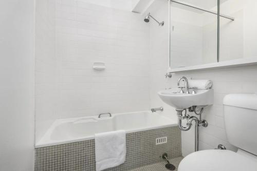a bathroom with a tub and a sink and a toilet at Stunning Ocean Views With Manly At Your Doorstep in Sydney
