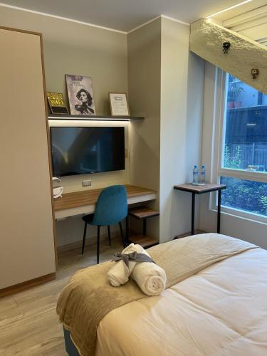 a bedroom with a bed and a desk and a television at Republica del Salvador Coliving Ecuador XOE in Quito
