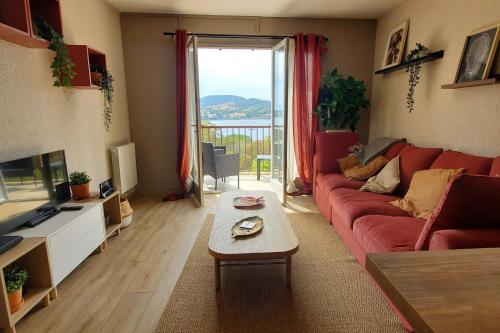 un salon avec un canapé rouge et une table dans l'établissement Lumineux appartement avec vue sur mer, à Saint-Raphaël