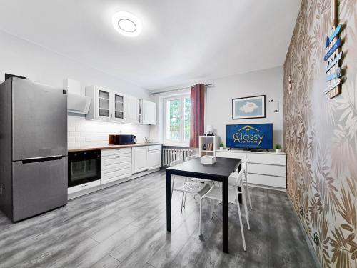 a kitchen with a black table and a refrigerator at CLASSY APARTMENTS - Gdynia - Experyment in Gdynia
