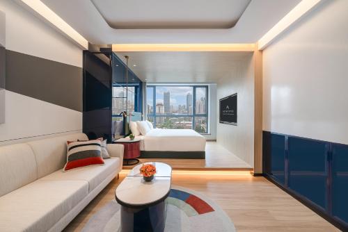 a living room with a couch and a bed at A T HOUSE Shanghai City Center Xujiahui - Free Night Snacks from 930pm-11pm in Shanghai