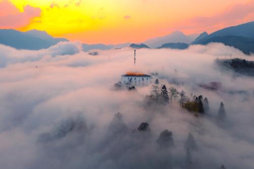 a view of a pagoda in the clouds at sunset at Silk Path Grand Sapa Resort & Spa in Sa Pa
