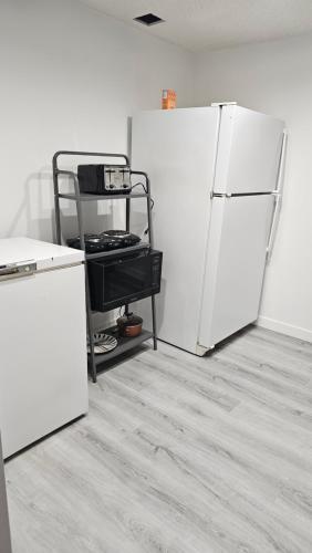 a kitchen with two white refrigerators in a room at Bright and Cozy Room with Free Parking in Edmonton