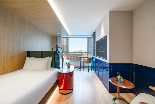 une chambre d'hôtel avec un lit et une table dans l'établissement A T HOUSE Shanghai Xujiahui, à Shanghai