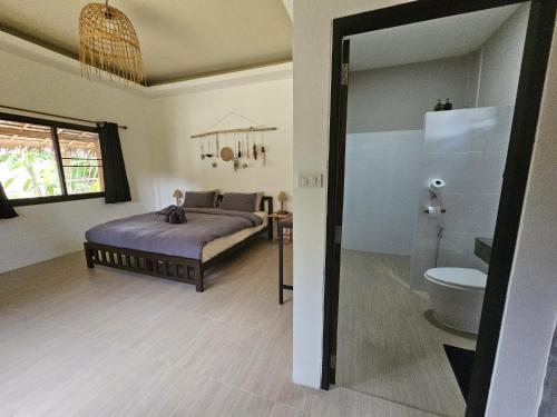a bedroom with a bed and a toilet in a room at The Mellow Mango in Ko Lanta