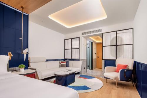 a bedroom with a bed and a living room at A T HOUSE Shanghai City Center Xujiahui - Free Night Snacks from 930pm-11pm in Shanghai