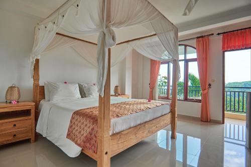 a bedroom with a canopy bed and a balcony at Attara Hills Sunset Villa Senggigi in Senggigi 