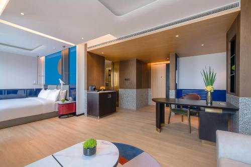 una camera d'albergo con letto e scrivania di A T HOUSE Shanghai Xujiahui a Shanghai