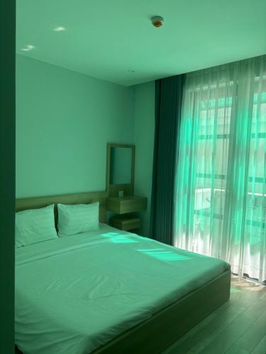 a bedroom with a large bed and a window at Green Inn Phu Quoc Hotel in Phu Quoc