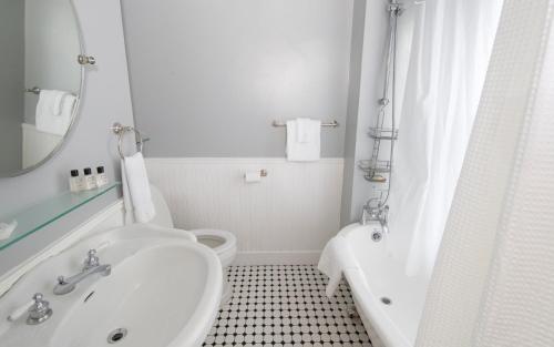 a bathroom with a sink and a tub and a toilet at The New London Inn in New London