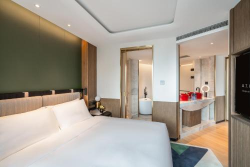 a bedroom with a white bed and a bathroom at A T HOUSE Shanghai City Center Xujiahui - Free Night Snacks from 930pm-11pm in Shanghai
