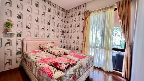 a bedroom with a bed and a wall covered in wallpaper at Vimala Hills Villa & Resort Megamendung Puncak in Bogor