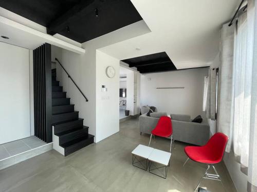 a living room with a couch and red chairs at Biei Villa Gen in Biei
