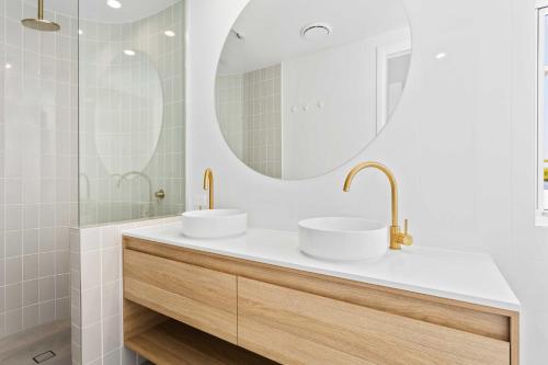 une salle de bain avec deux lavabos et un miroir dans l'établissement Haven On Hooper, à Gold Coast