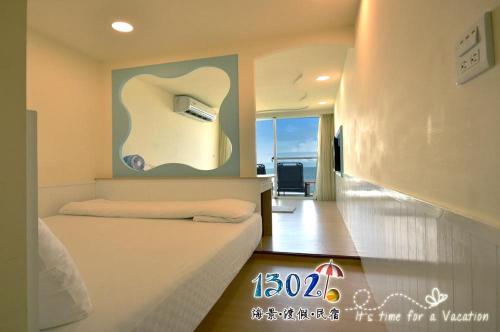 a bedroom with a bed and a painting on the wall at 1302海景民宿 in Xiaoliuqiu