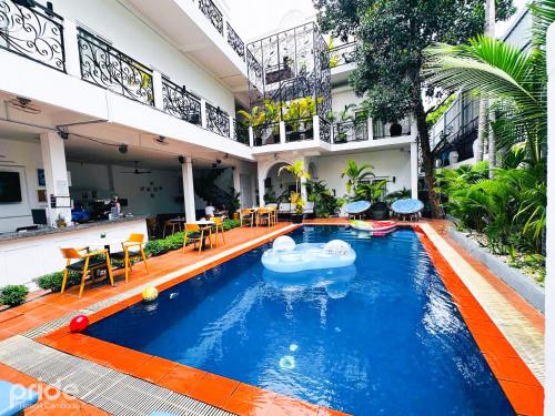 uma piscina numa casa com um macarrão de piscina no meio em Pride Resort Cambodia em Phnom Penh