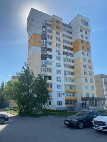 a large building with cars parked in a parking lot at Идеальная 4-х комн, с домашним уютом и простором in Kostanay