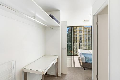 a room with a desk and a bed and a window at Rhapsody Resort - Official in Gold Coast