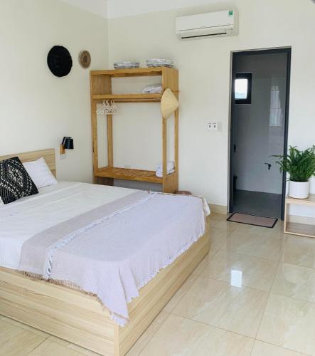 a bedroom with a large bed and a shelf at Della Luna Tam Coc Ninh Binh in Ninh Binh