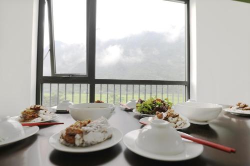 een tafel met kommen en borden met eten erop bij Lang Can Boutique Hotel in Bản Kien