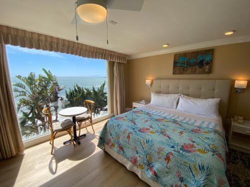1 dormitorio con 1 cama y vistas al océano en Cliff House Inn, en Carpinteria