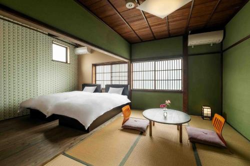 a bedroom with a large bed and a table at Hisago in Kanazawa